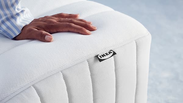 une vue rapprochée de la main d’une personne posée sur un matelas