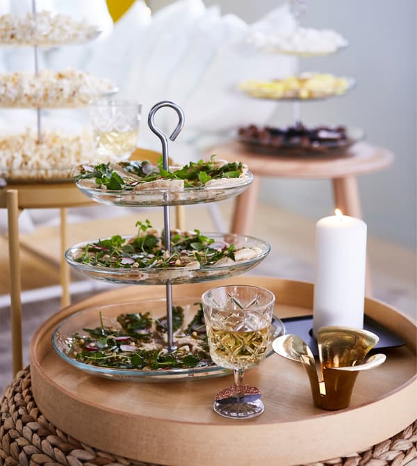Use several space-saving three tier serving platters for snacks and nibbles. Place them on side tables and stools around the living room. This way guests will mingle and make new friends instead of ending up in one spot.