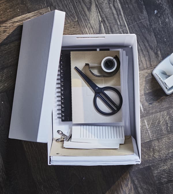 Utilisez un mélange uniforme de mobilier de bureau moderne pour votre bureau dans le séjour. Rangez les ciseaux, les adhésifs et les papiers dans une jolie boîte avec des poignées prédécoupées. La boîte de rangement IKEA TJENA blanche est composée d’au moins 80% de papier recyclé!