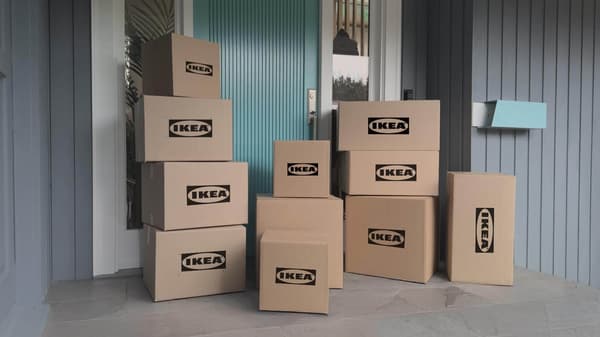 Varias cajas de envío color café en un porche delantero con el logotipo de IKEA en ellas.
