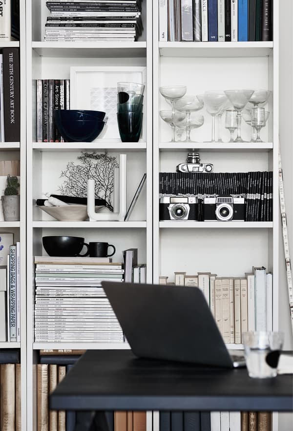 Verres et livres dans un rangement ouvert.