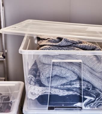 Vêtements d’hiver rangés dans des boîtes de plastique transparent.