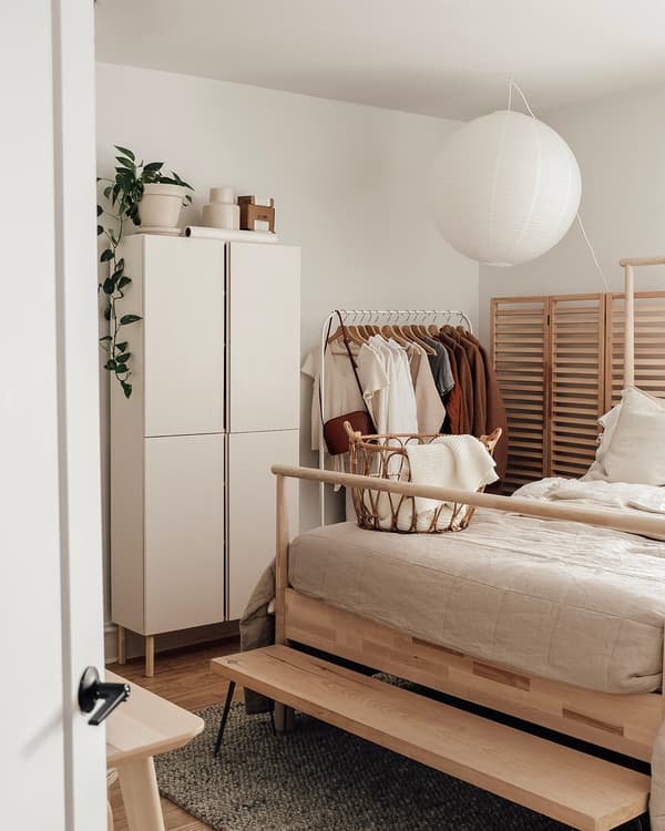 View of Emilie's airy bedroom with bed and clothing storage.