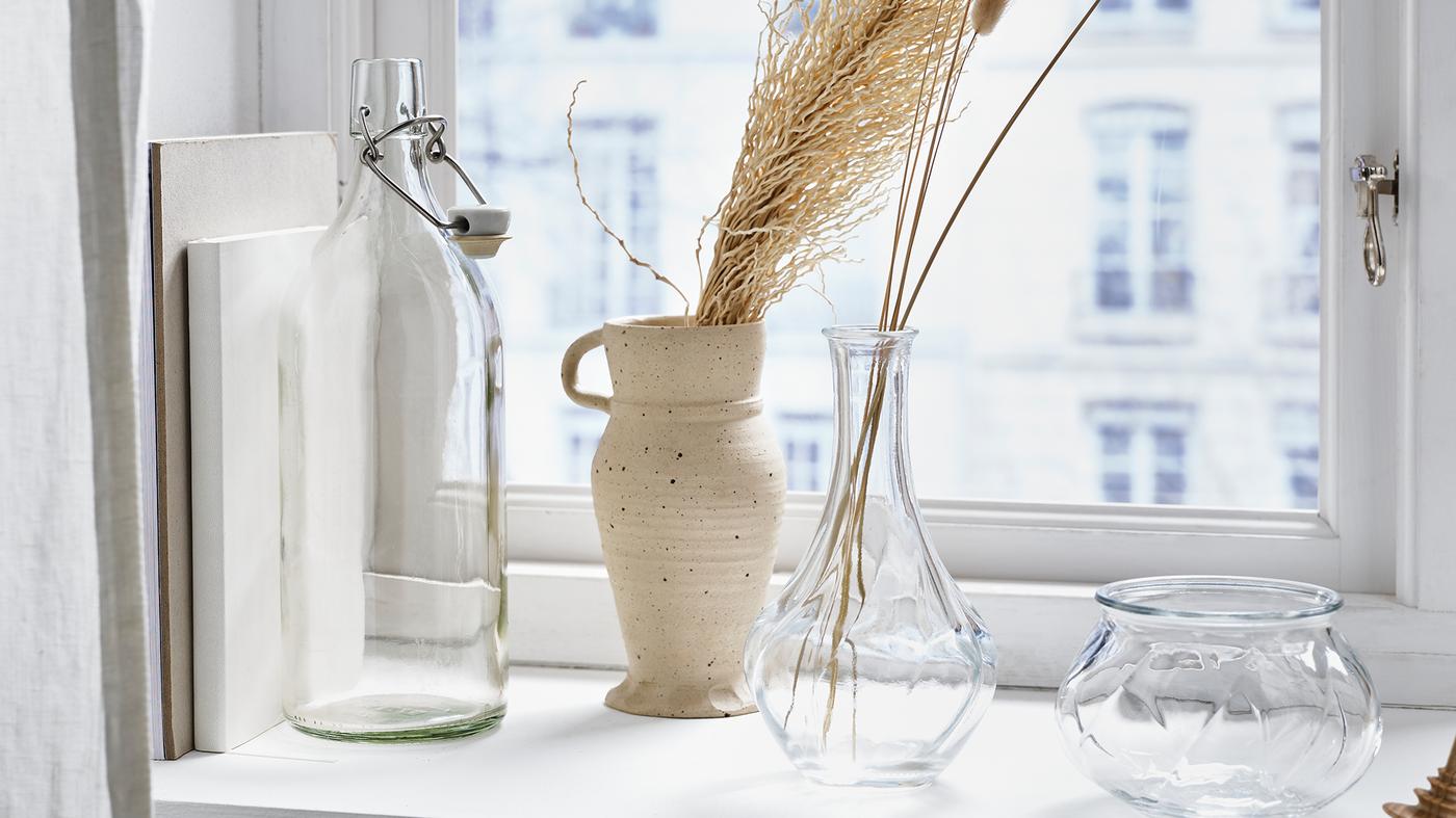 VILJESTARK vases on a window ledgfe beside a KORKEN jar.