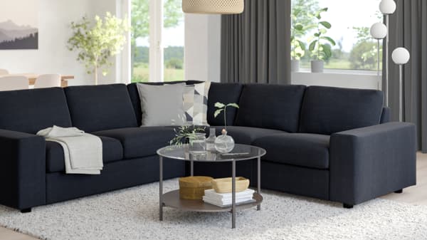 VIMLE modular sofa in black with L-shaped setup, styled in a modern room with dark curtains and round glass coffee table.