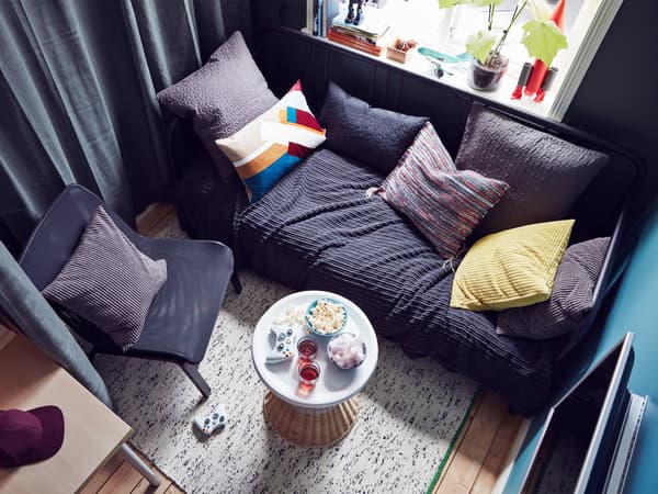 Vue aérienne de la zone détente d’une chambre à coucher d’ado, avec divan, fauteuil et table de nuit 