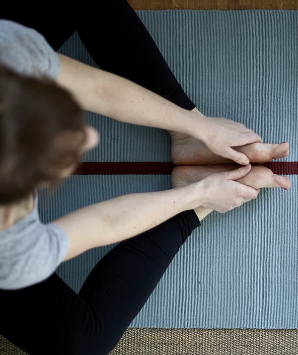 Vue d’ensemble de Eva pratiquant le yoga sur un matelas bleu.