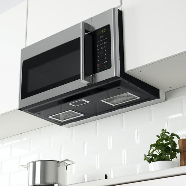 Vue sur un four à micro-ondes fixé au mur avec hotte intégrée. 
