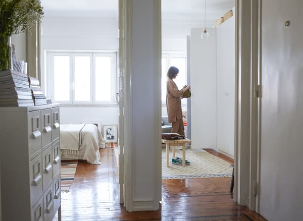 Vue vers la chambre à coucher, montrant Carolina en train d’ouvrir sa garde-robe.