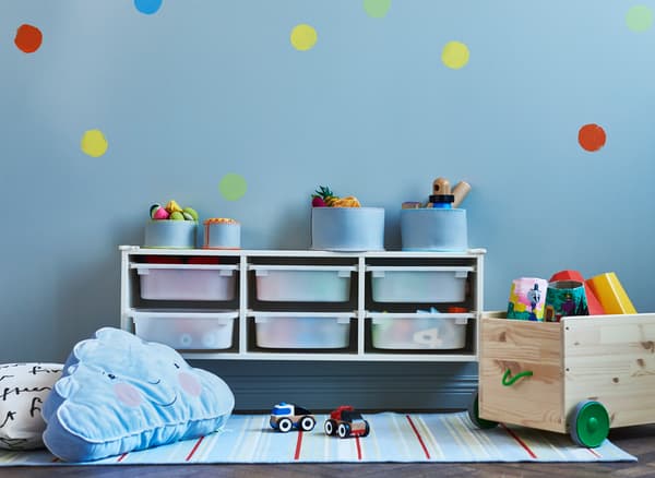 Wall storage placed above a changing table during infant years can be moved down to floor level later for toy storage