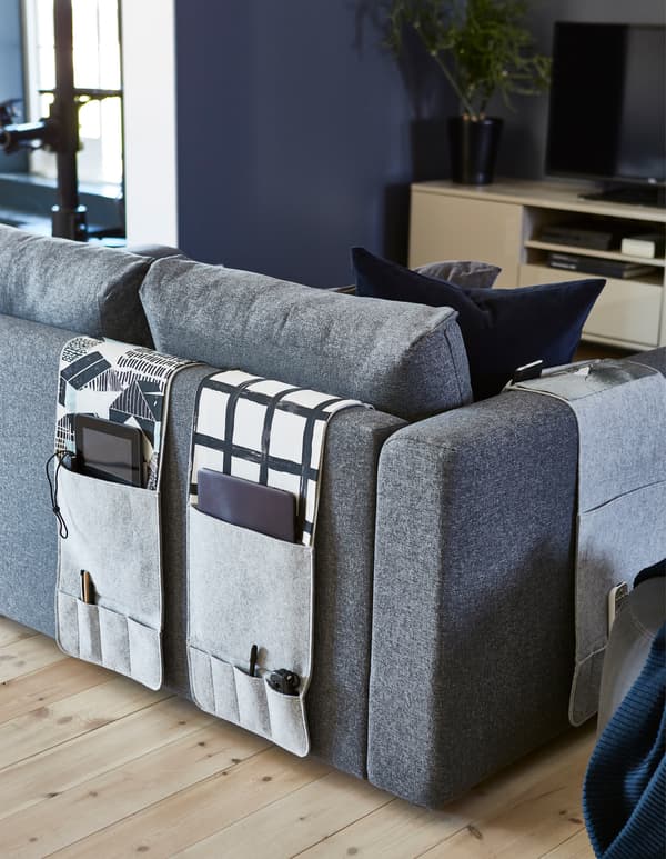 Want a sofa organiser? KNALLBÅGE from IKEA is a grey felt hanging organiser for accessories with pockets for remotes, magazines and more. It can drape over the arms or back of your sofa.