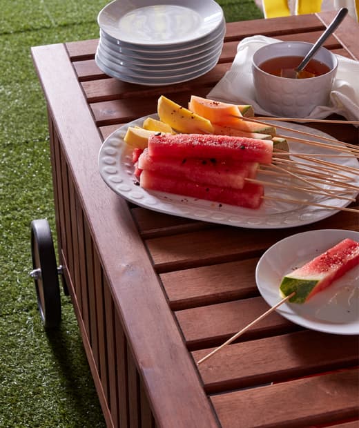 Watermelon and mango slices put on IKEA GRILLTIDER bamboo skewers on a big, white plate.