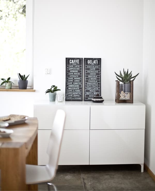 White cabinets against a white wall in an eat-in kitchen.