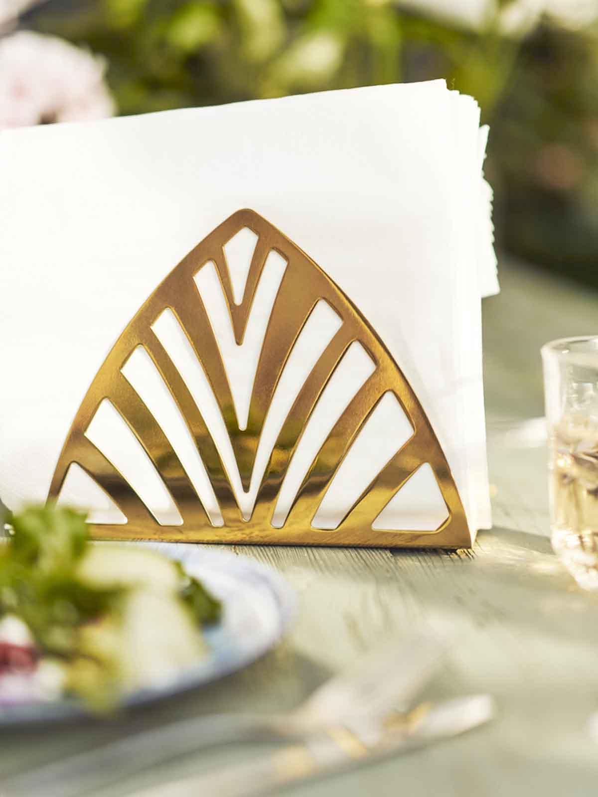 White FANTASTISK napkins sandwiched in between brass-colour TILLSTÄLLNING napkin holder.