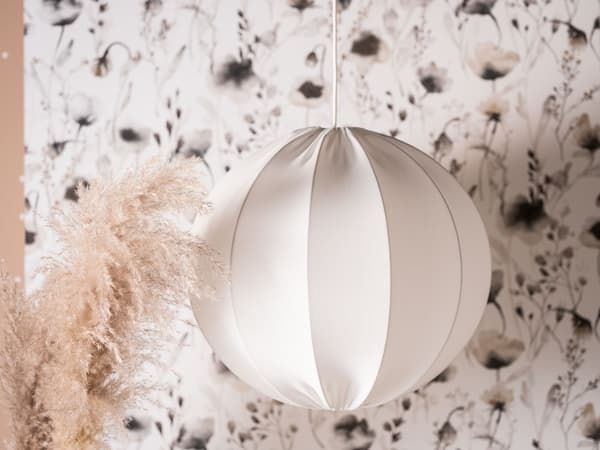 White pendant lamp shade in front of wall paper