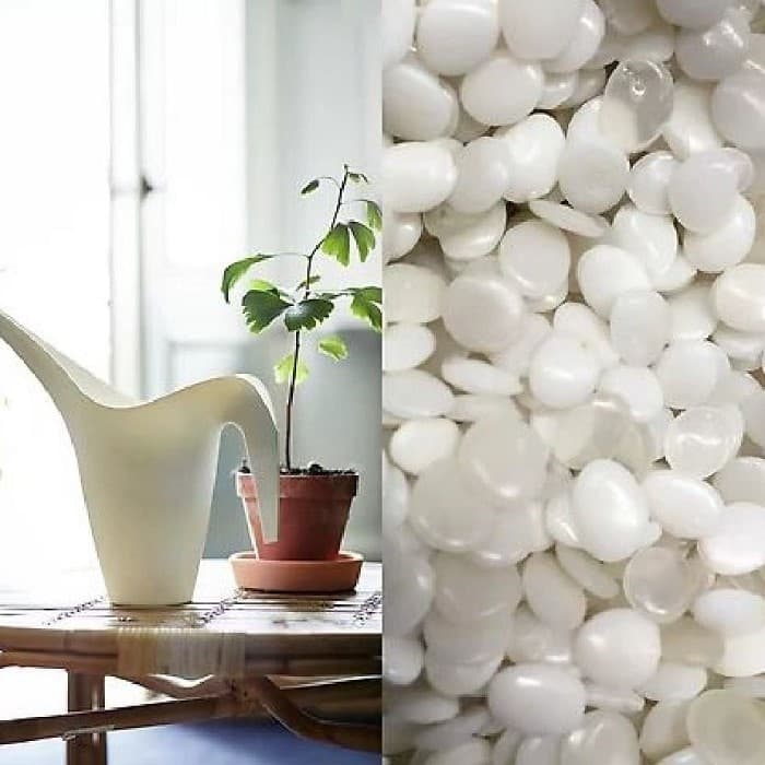White plastic pellets shown alongside a molded plastic watering can.