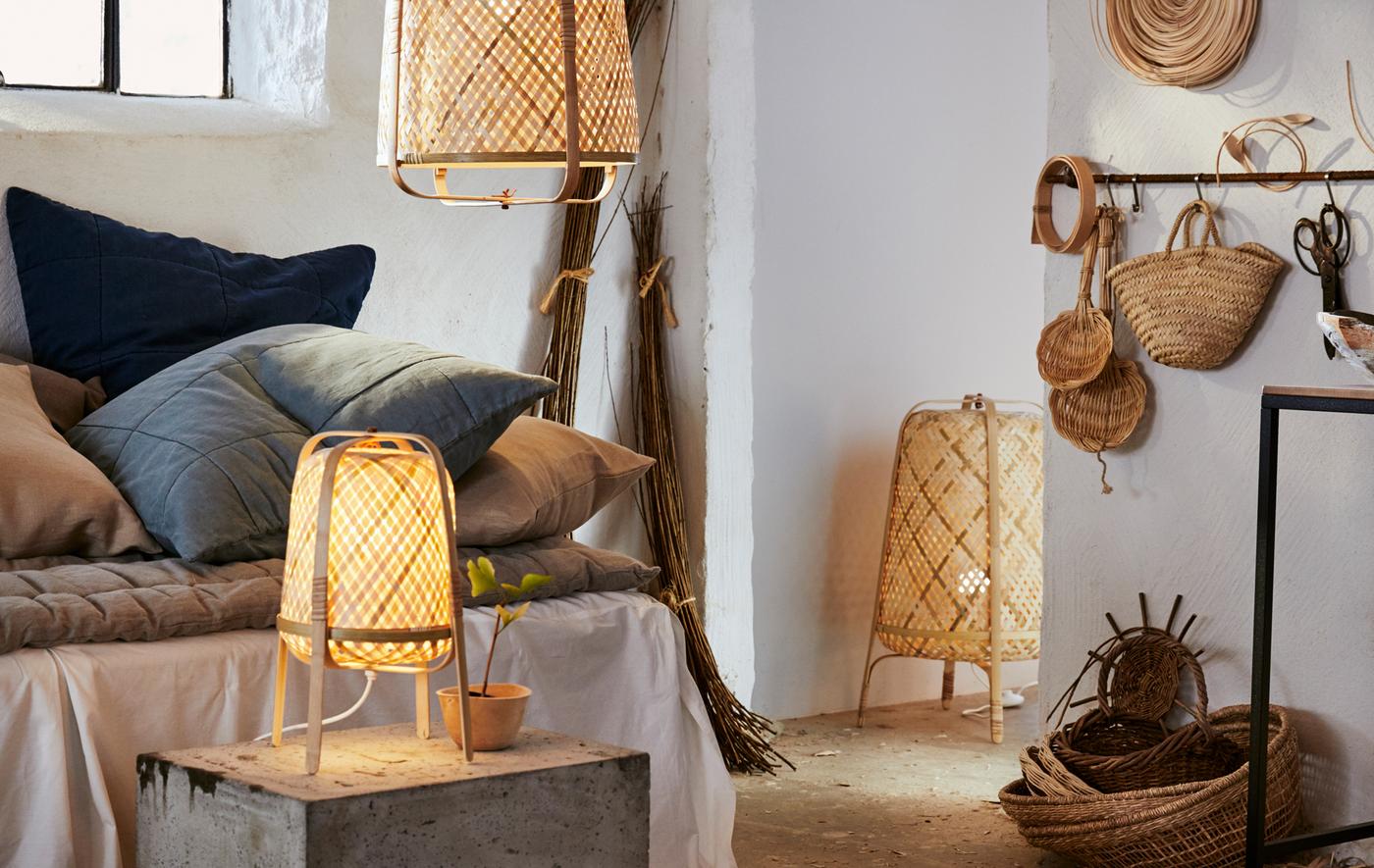 White room with neutral textiles, rattan baskets, and KNIXHULT floor lamp, table lamp and pendant lamp.