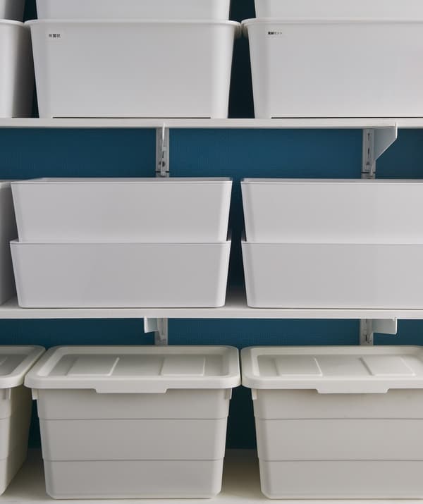 White storage boxes stacked on shelves.
