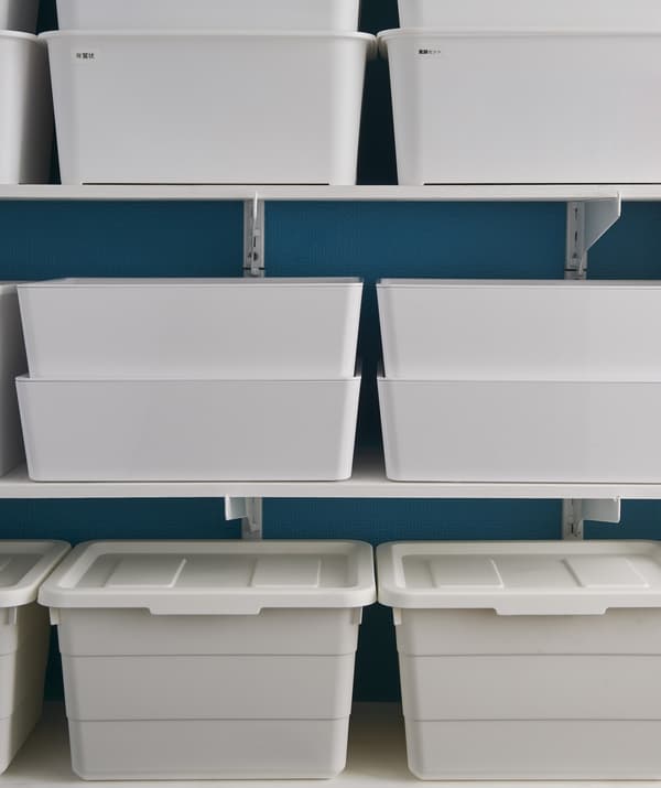 White storage boxes stacked on shelves.