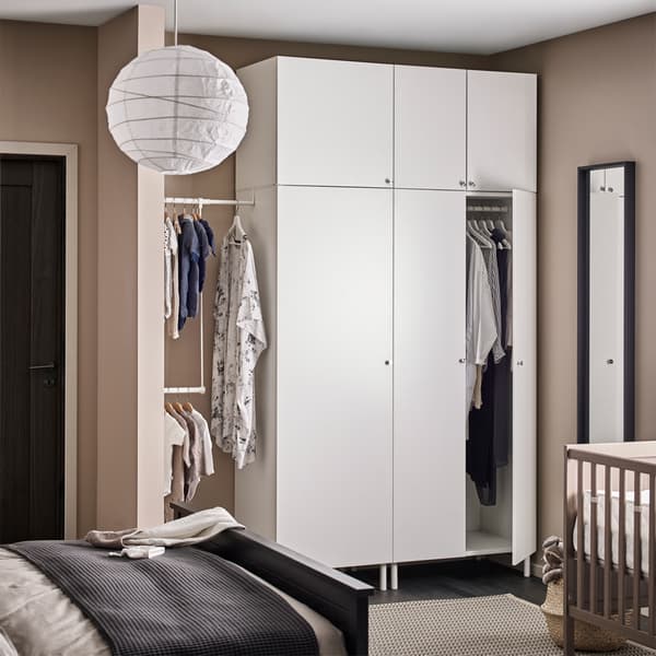 White storage cupboards in a beige bedroom.