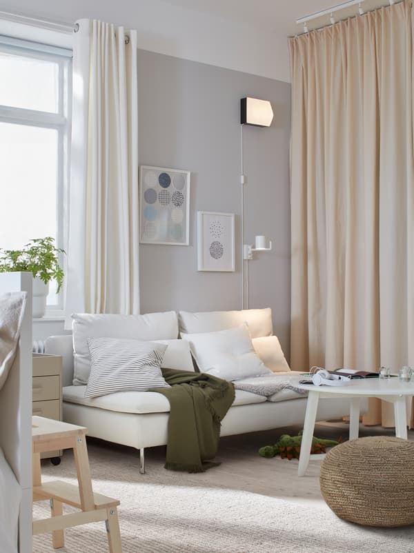 Wohnzimmer mit einem SÖDERHAMN Sofa, einem Couchtisch und Sitzkissen. Daneben ist eine deckenhohe Vorhangslösung zu sehen.