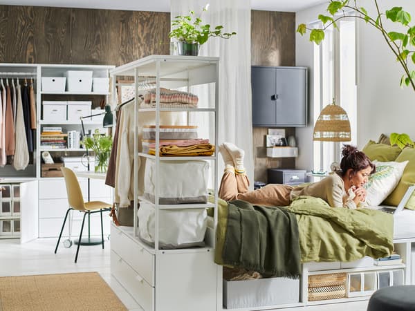 Woman in the bedroom with PLATSA storage and shelves.