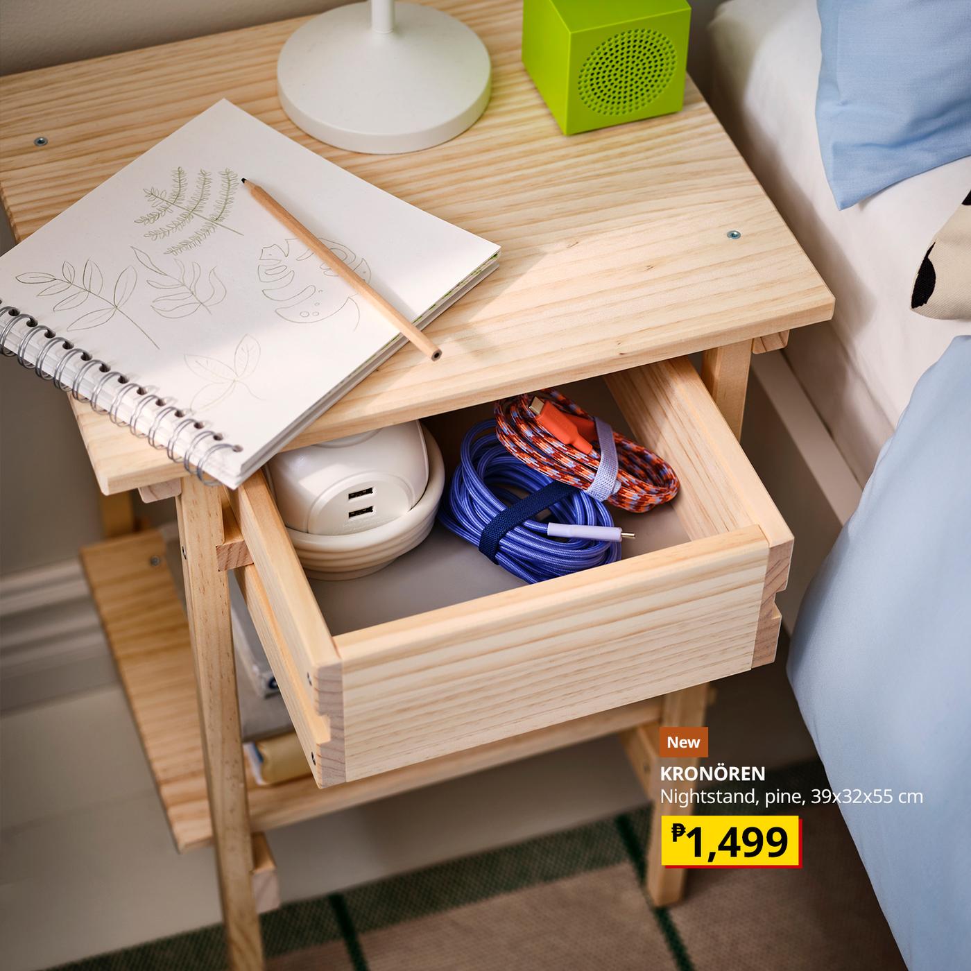 Wooden bedside table with sketchbook, lamp, green speaker, and open drawer holding cables and a device; IKEA-style ad shows price P1,499.