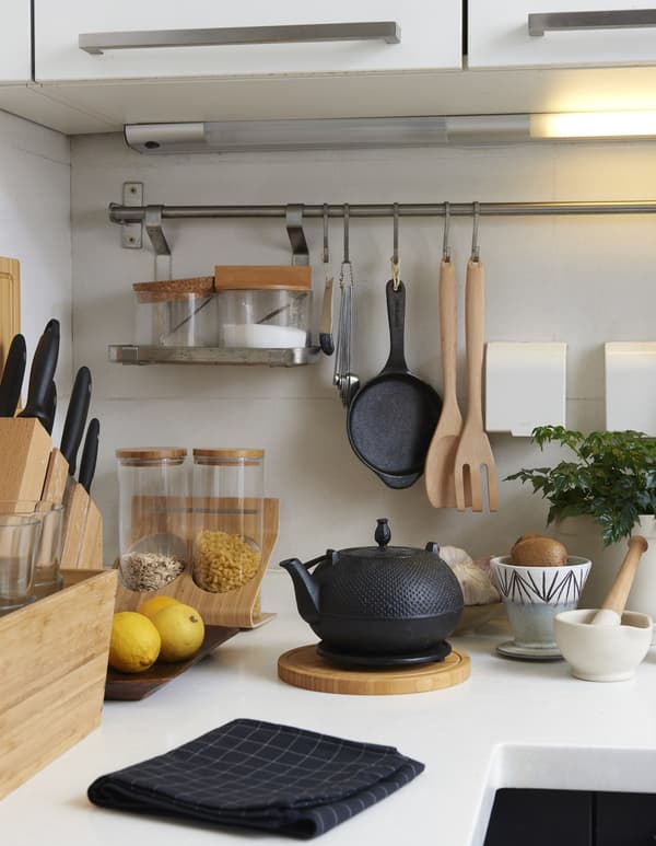 Wooden kitchen items on a white kitchen counter.