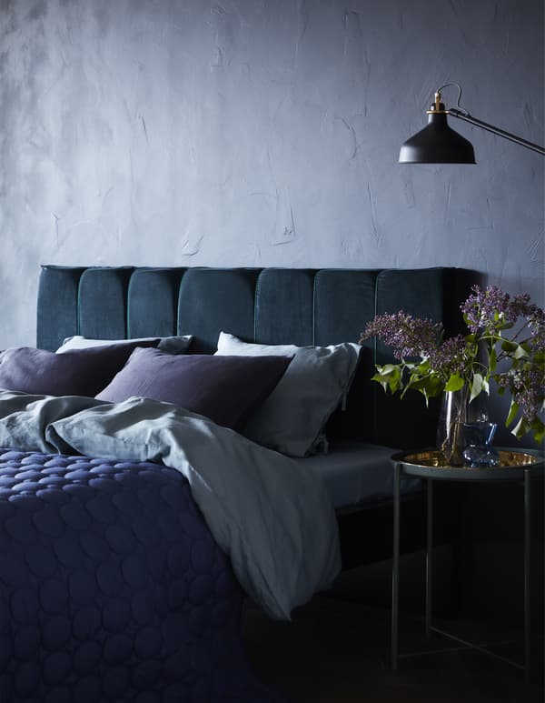 You can turn a MALM bed frame from IKEA into a DIY padded headboard. We did it with some foam cut into panels and a dark blue velvet curtain as the upholstery.