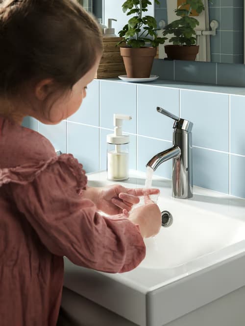 Young girl running a bathroom faucet
