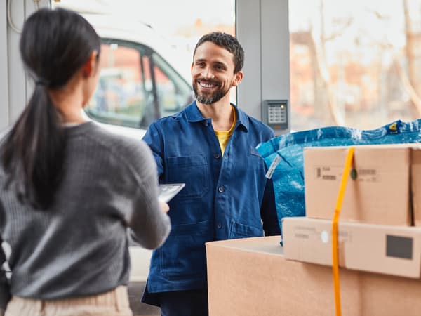 Zaposlena v podjetju IKEA izdaja pakete, stranka pa jih prevzema.