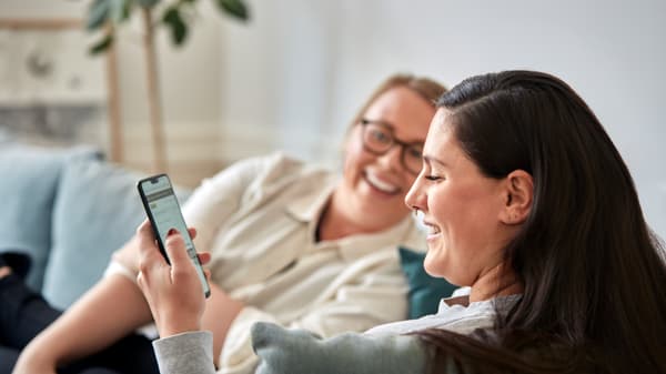 Zwei Frauen schauen auf Ihr Handy und Lachen