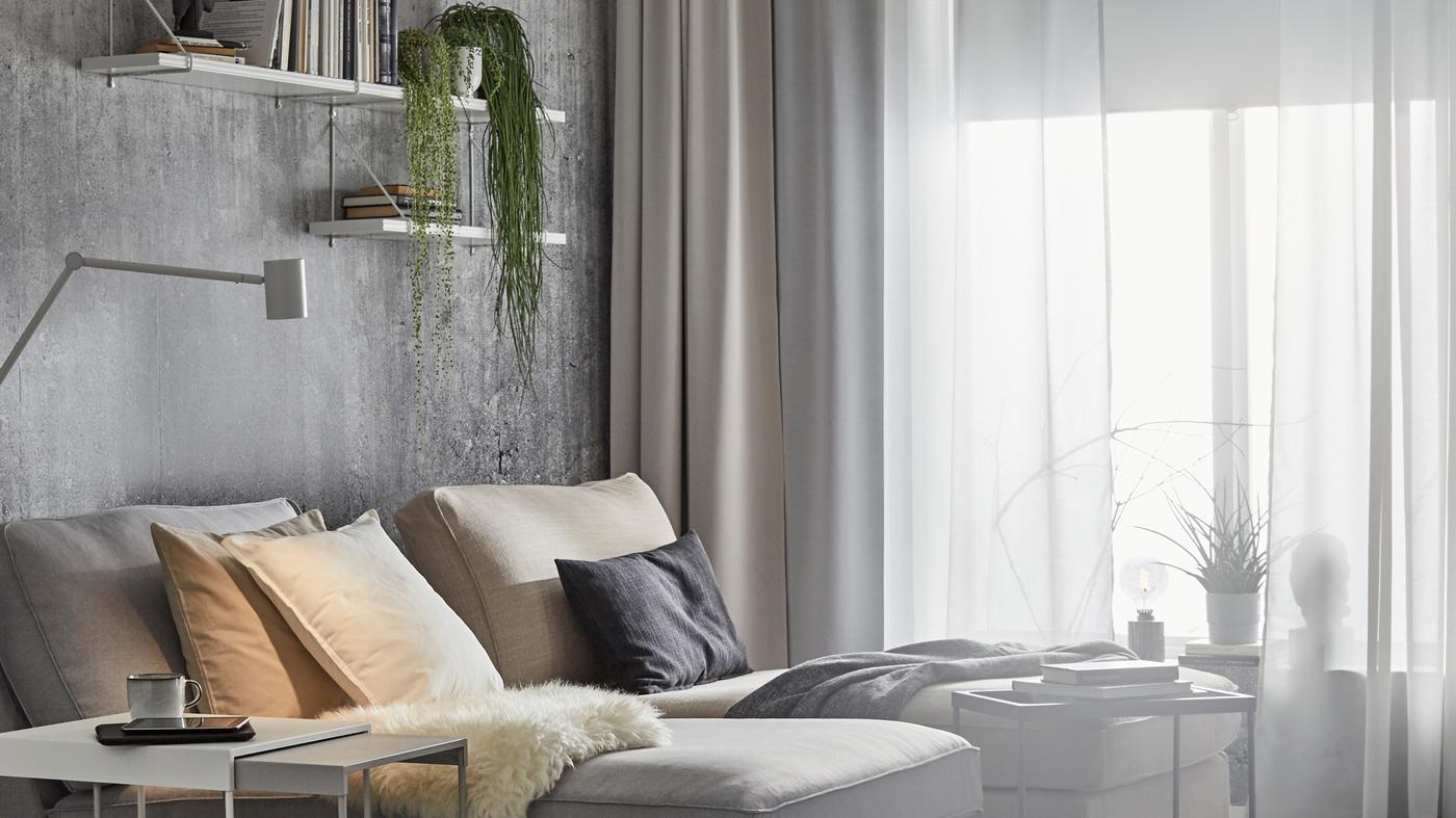 Zwei KIVIK Récamieren in Nähe eines Fensters mit verschiedenen Gardinenschichten inklusive HILLEBORG Gardinen mit Verdunklungsfunktion.