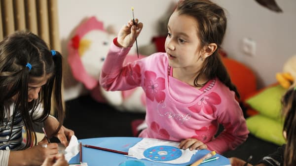 Zwei kleine Mädchen nehmen an einem Bastelworkshop teil