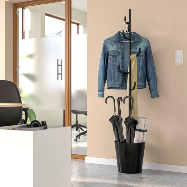 Black ÄLGANÄS coat stand holds denim jacket, beige coat, umbrellas, and yoga mat in compact home entry.