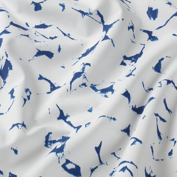 White fabric with blue brushstroke pattern. Soft, textured, high-quality cotton.