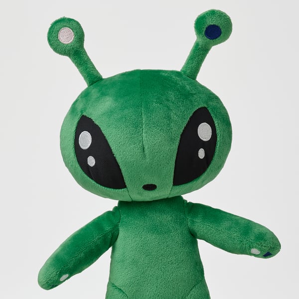 Alien-style cuddly toy with large black eyes and antennae, arms outstretched, made of soft recycled material.