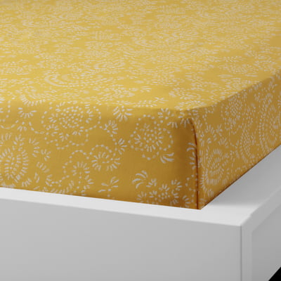 Yellow patterned cotton flat sheet displayed on a white bed, showcasing its soft, breathable fabric and envelope pillowcase design.