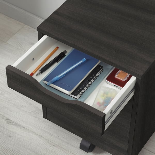 Open ALEX drawer unit with pens, notebooks, and office supplies neatly organised inside.