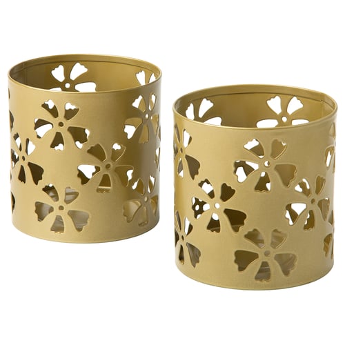 Two gold-colored cylindrical candle holders with intricate floral cutouts, made from coated galvanised steel, creating a warm and festive atmosphere.