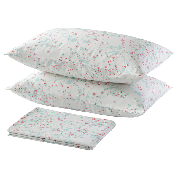 A bedding set called ASKLÖNN featuring cherry blossom prints in white, with two pillows and a folded sheet made of soft, 100% cotton fabric.
