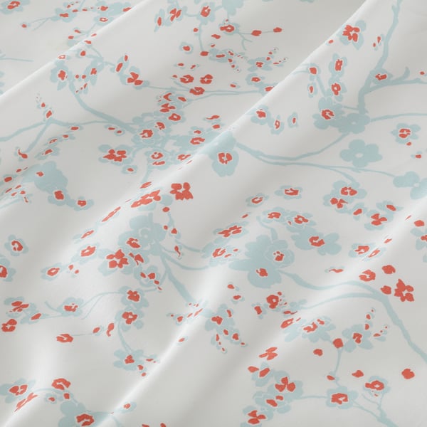 White cotton sheet with light blue cherry blossom branches and small red flowers, showcasing a delicate and soft design.