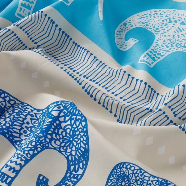 Blue fabric with intricate elephant designs and wavy patterns, showcasing high-quality cotton texture.