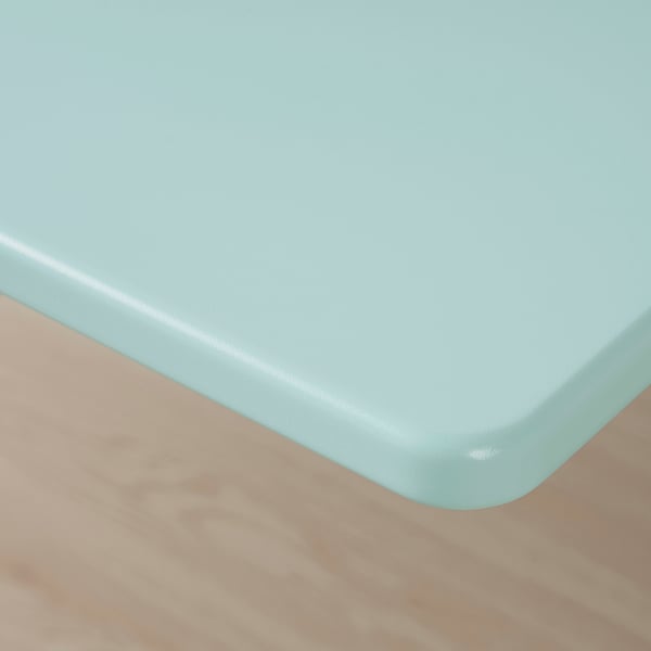 Smooth, light blue desk surface, slightly tilted; sturdy, round edges.