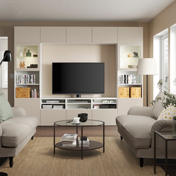 Modern living room with flat-screen tv on BESTÅ unit, sofas, coffee table, and lamp.