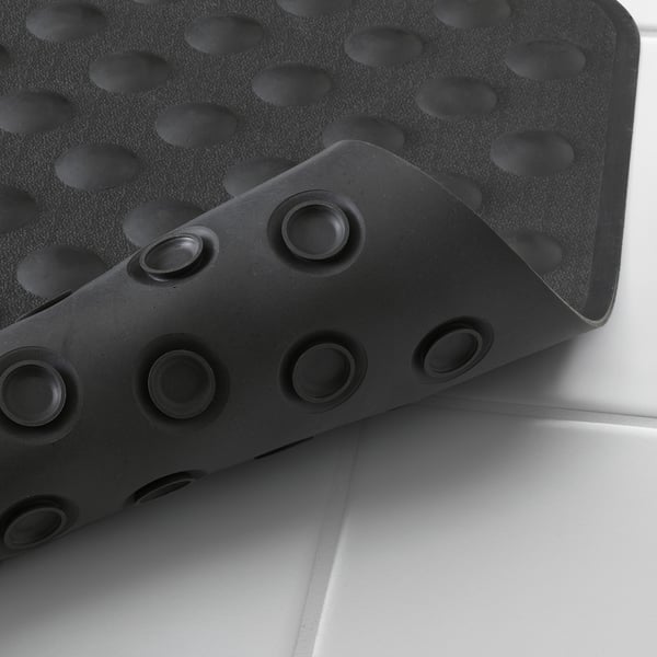 Black bath mat with suction cups, designed for secure grip and drainage.