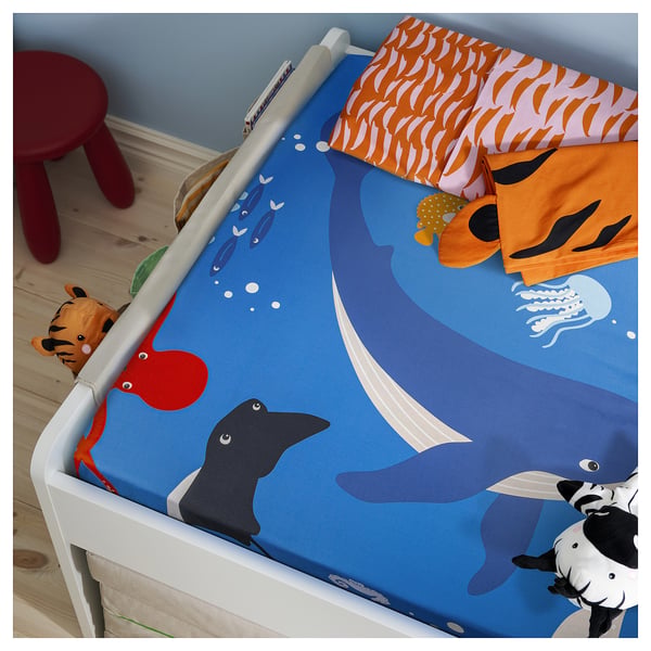 A BLÅVINGAD crib bedsheet with whale and fish designs in dark blue. Made of 80% cotton, 20% viscose.