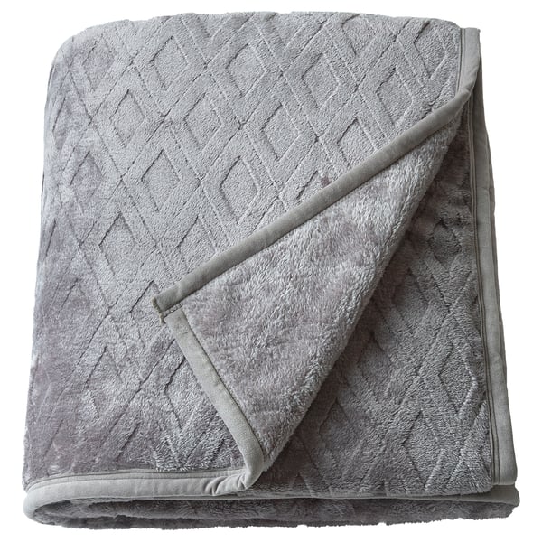 Folded soft grey blixxabacken blanket with textured diamond pattern, made from recycled polyester fleece, offering warmth and comfort.