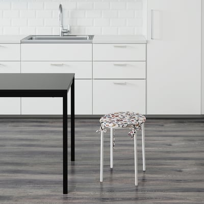 Decorative kitchen stool with floral seat by sink.