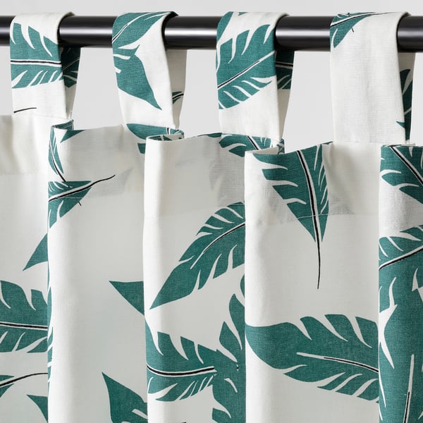 Curtains hung with eyelet heading, providing light control and privacy. Large tropical leaf pattern, sold in pairs.